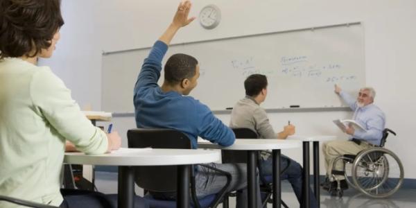 Un profesor universitario con discapacidad dando clase.