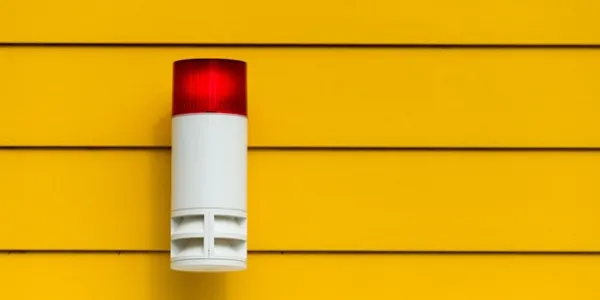 Luz roja de una alarma con un fondo de pared amarilla