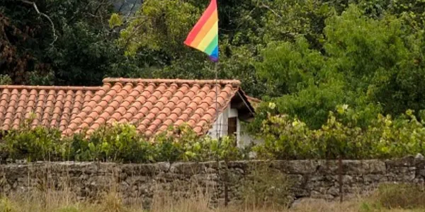 Casa de un pueblo con la bandera LGTBIQ+