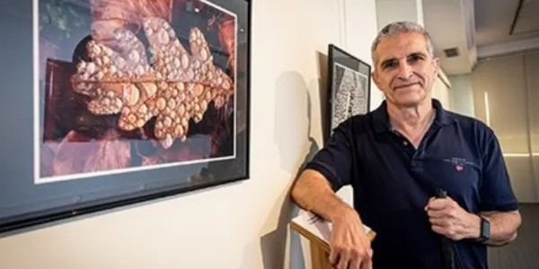 Rafael Zapata al lado de una de las fotografías que expone