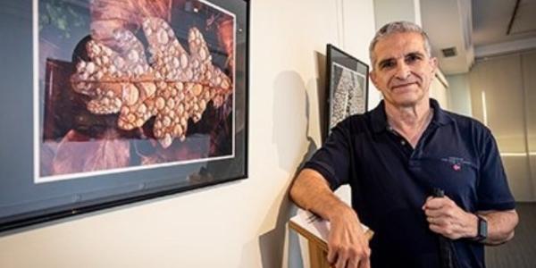 Rafael Zapata al lado de una de las fotografías que expone