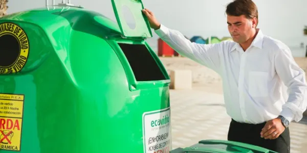 Un hombre se dispone a reciclar vidrio cerca de una playa