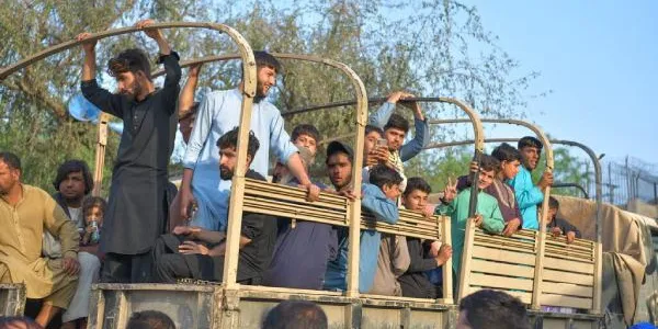 Hombres afganos cruzan la frontera de Torkham desde Pakistán hacia Afganistán