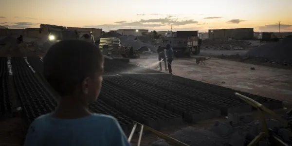 ¡Un niño observa cómo se humedecen bloques de cemento