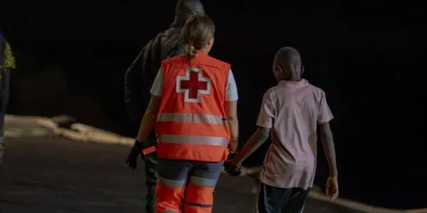 Un trabajador de la Cruz Roja atiende a menores migrantes llegados a Canarias