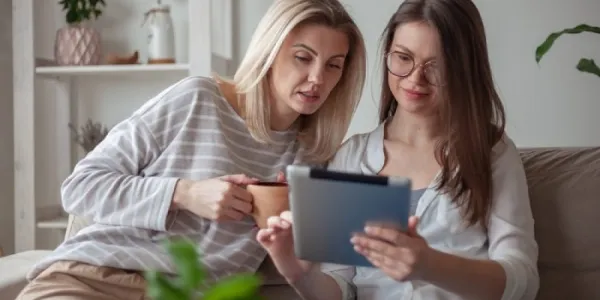 Una madre y una hija consultan una tablet