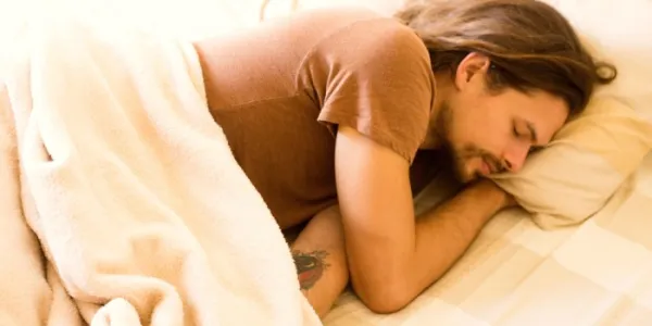 Un hombre duerme en su cama 
