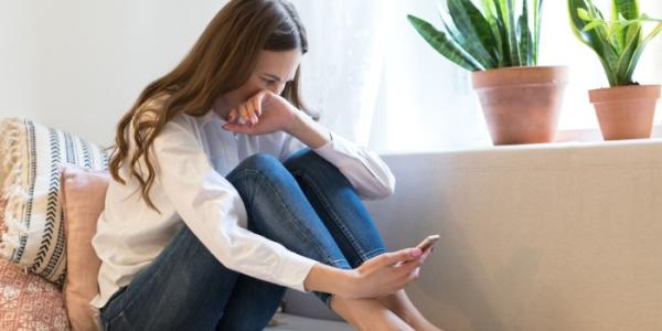 Mujer llorando mirando el móvil tras una ruptura