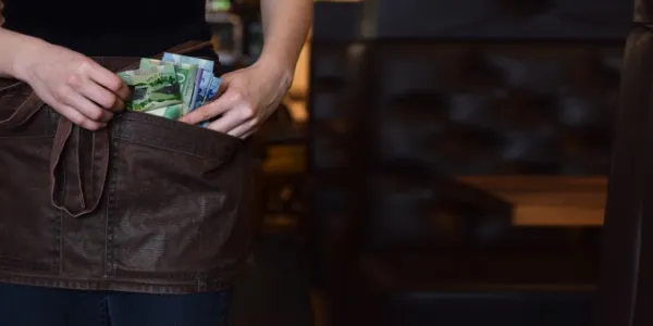 Camarera guardándose el dinero