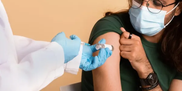 Un profesional sanitario vacuna a un hombre