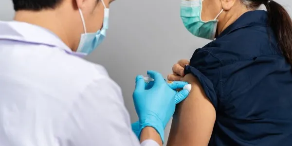 Un profesional sanitario vacuna a un paciente