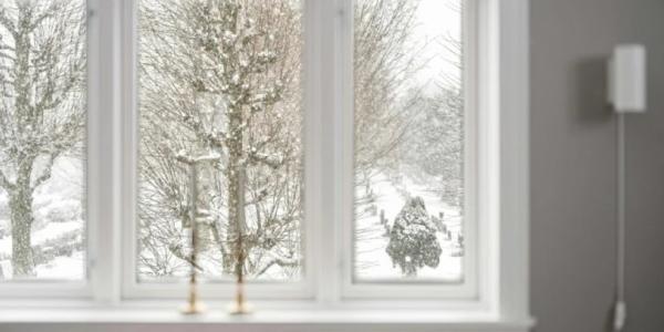 Ventana de una casa con vistas a un paisaje nevado