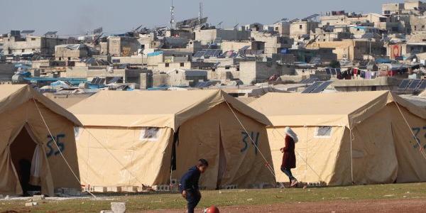 Niño jugando en un campo de personas desplazadas en Siria