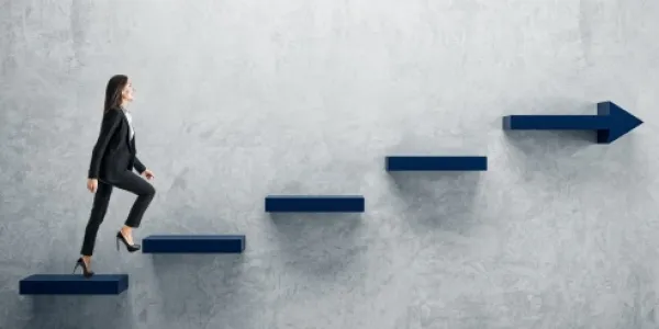 Mujer empresaria subiendo los peldaños de una escalera en la pared