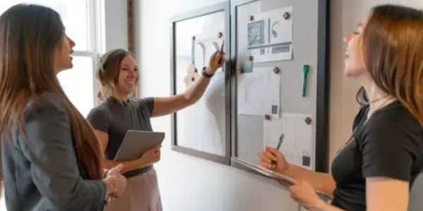 Varias mujeres reunidas frente a una pizarra hablando de tecnología sanitaria