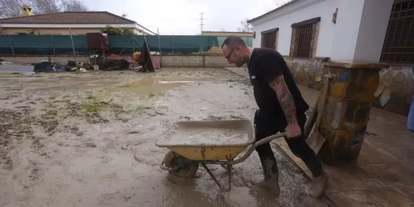 Vecinos de las parcelas próximas al río Guadalquivir limpian el lodo acumulado por el temporal