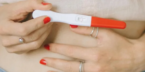 Mujer con un test positivo de embarazo. 