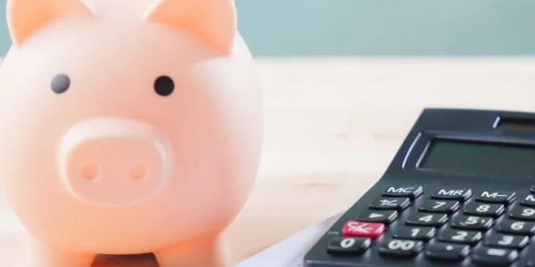 Imagen de una hucha con forma de cerdito y una calculadora