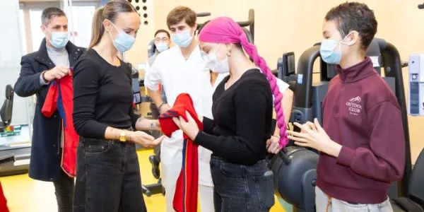 Virginia Torrecilla entregando una camiseta a una niña