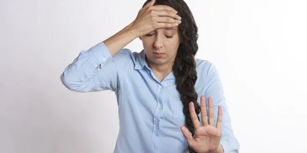 Una mujer se toca la cabeza por vértigo