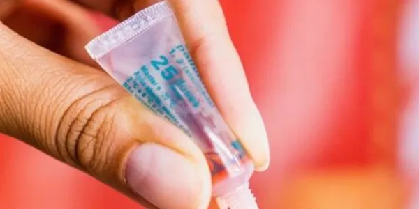 Mano de un médico administrando una vacuna oral a un niño