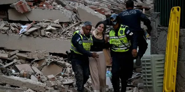 Equipos de emergencia ayudan a una persona a salir de los escombros de un edificio tras el terremoto.