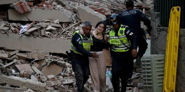 Equipos de emergencia ayudan a una persona a salir de los escombros de un edificio tras el terremoto.