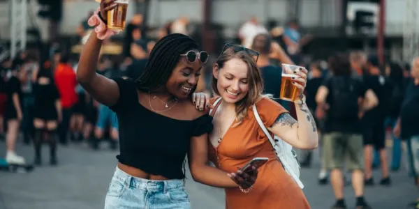 Dos chicas en un festival con cervezas en la mano