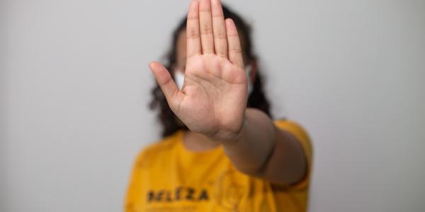 Mujer con una mano parando la violencia de género