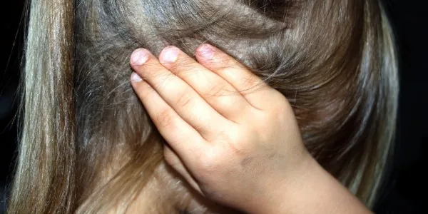 Niña tapándose los oídos