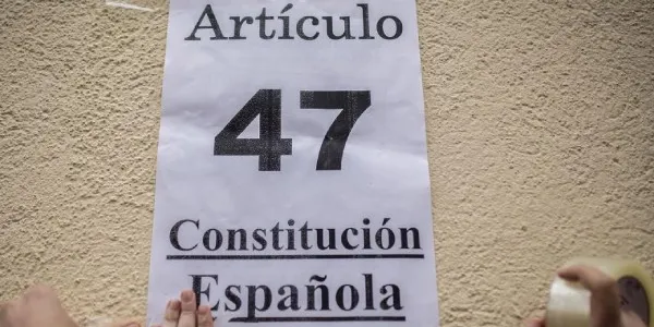 28 de enero de 2016. Activistas pegan un cartel con el artículo de la Constitución que recoge el derecho a la vivienda en el exterior de un edificio donde estaba previsto el desahucio de Nerea.