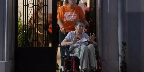 Maricarmen sale del portal a saludar durante una concentración bajo el lema ‘Maricarmen se queda’.