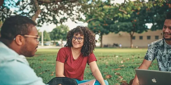 Jóvenes sentados en el campus de una universidad