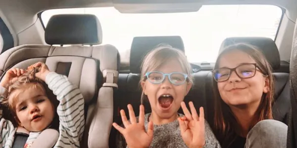 Tres niñas de diferentes edades viajan en el asiento trasero de un coche