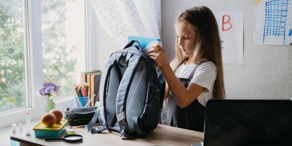 Regreso a clases, higiene de los escolares, precauciones de seguridad después del coronavirus. La colegiala va a la escuela y se lava las manos con desinfectante